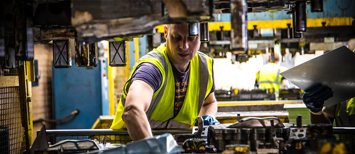 Pressmark team loading a component into a production press